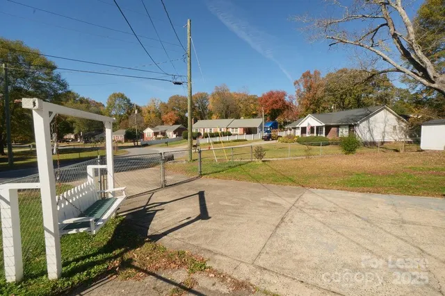 a view of a swimming pool with a patio and a yard
