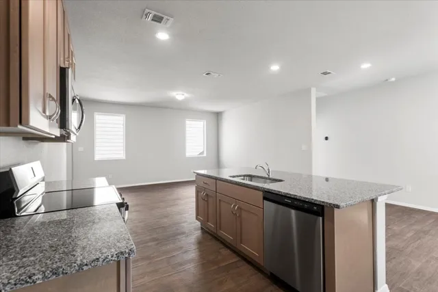 a kitchen with stainless steel appliances granite countertop a sink stove and microwave