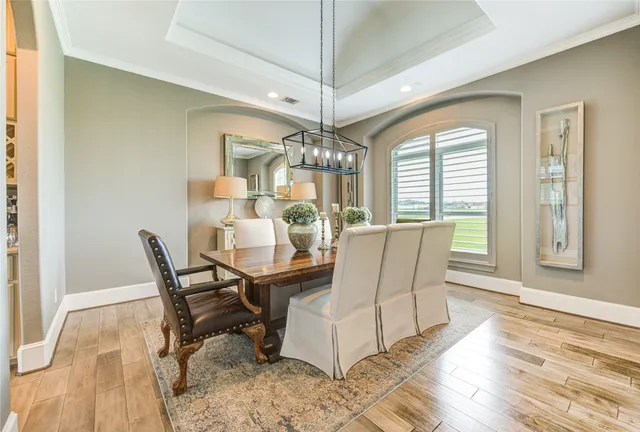 a dining room with furniture a chandelier and wooden floor