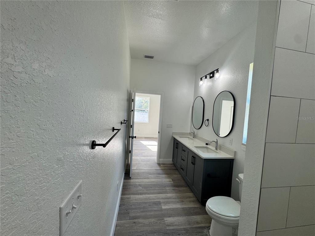 12757 Southeast 104th Terrace Belleview, FL 34420 - Photo 11 of 22 a bathroom with a sink a toilet and a mirror