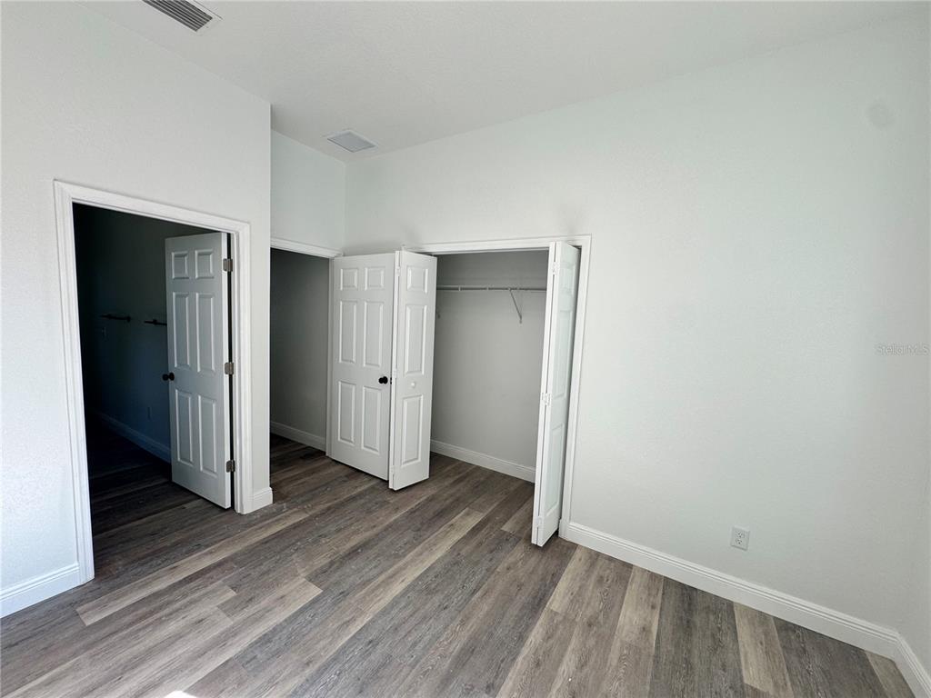 12757 Southeast 104th Terrace Belleview, FL 34420 - Photo 13 of 22 an empty room with wooden floor & closet area