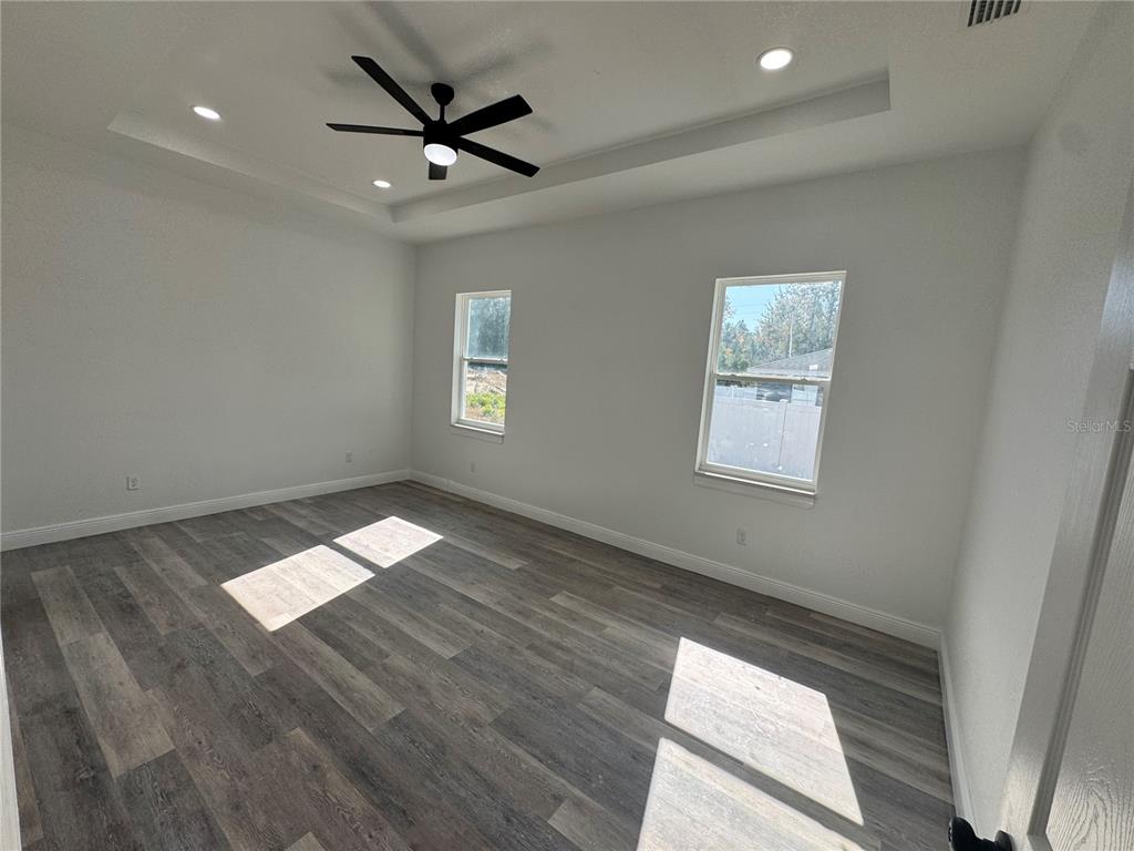 12757 Southeast 104th Terrace Belleview, FL 34420 - Photo 15 of 22 a view of empty room with wooden floor and fan