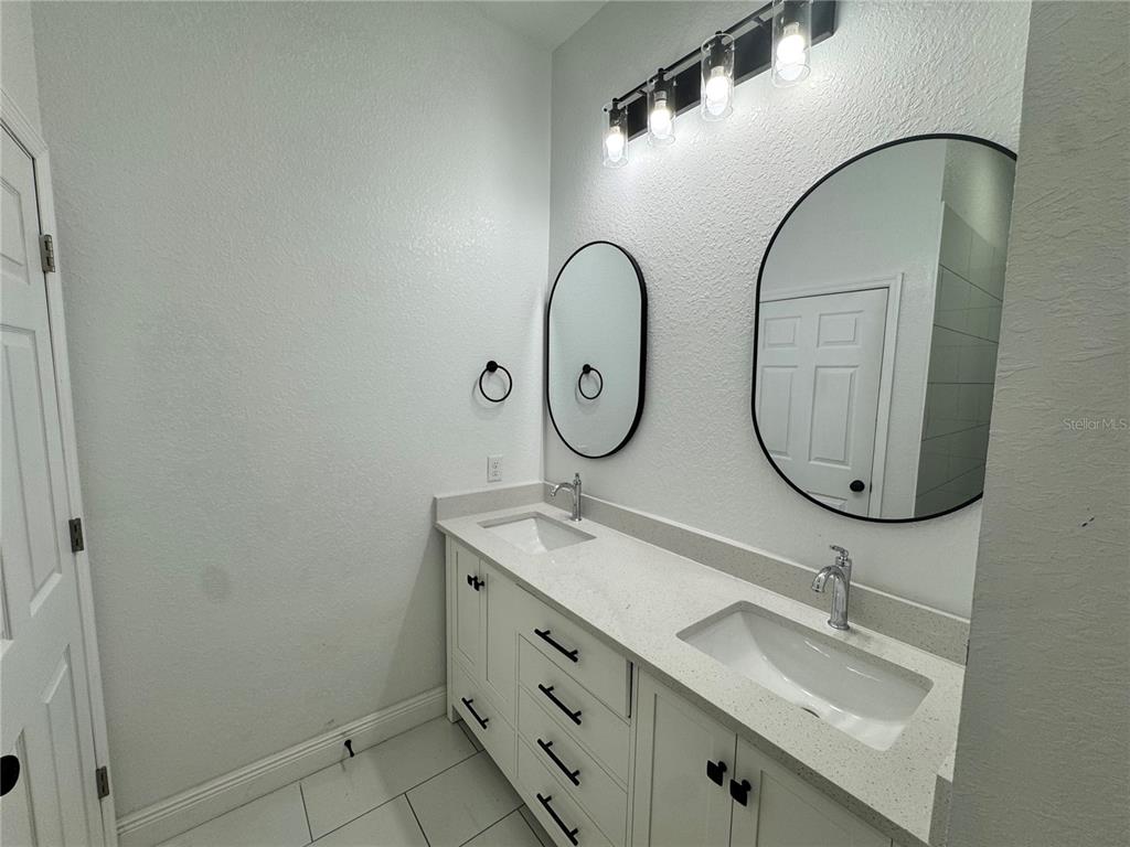 12757 Southeast 104th Terrace Belleview, FL 34420 - Photo 21 of 22 a bathroom with 2 sink and a mirror