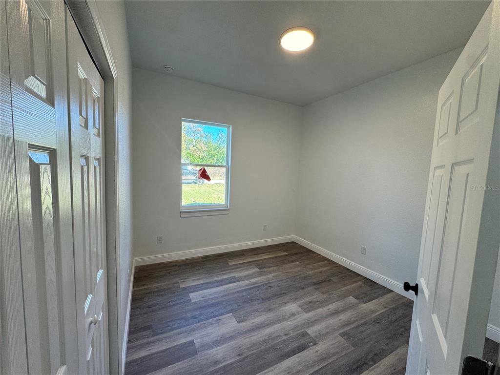 12757 Southeast 104th Terrace Belleview, FL 34420 - Photo 10 of 22 an empty room with wooden floor and windows