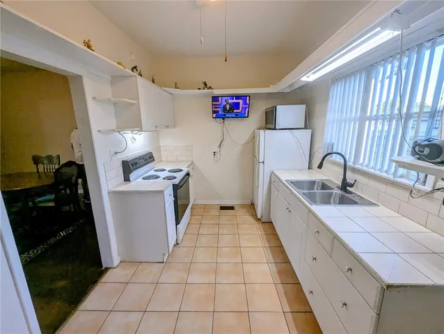 a kitchen with granite countertop a sink stove and cabinets