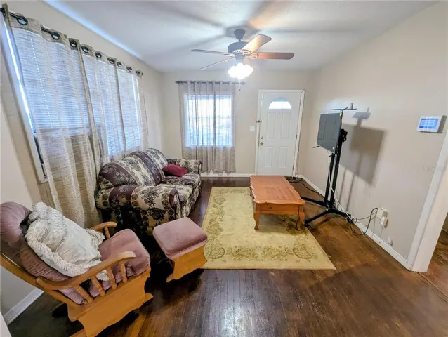 a living room with furniture and wooden floor