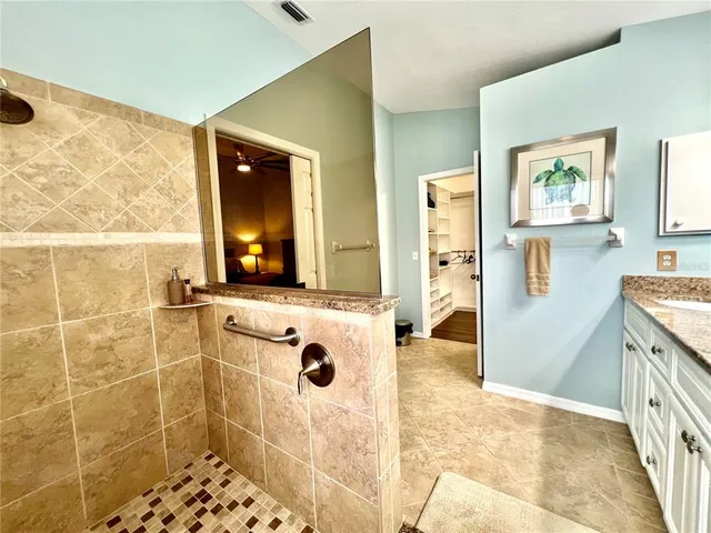 a bedroom with a large bed chandelier and a window