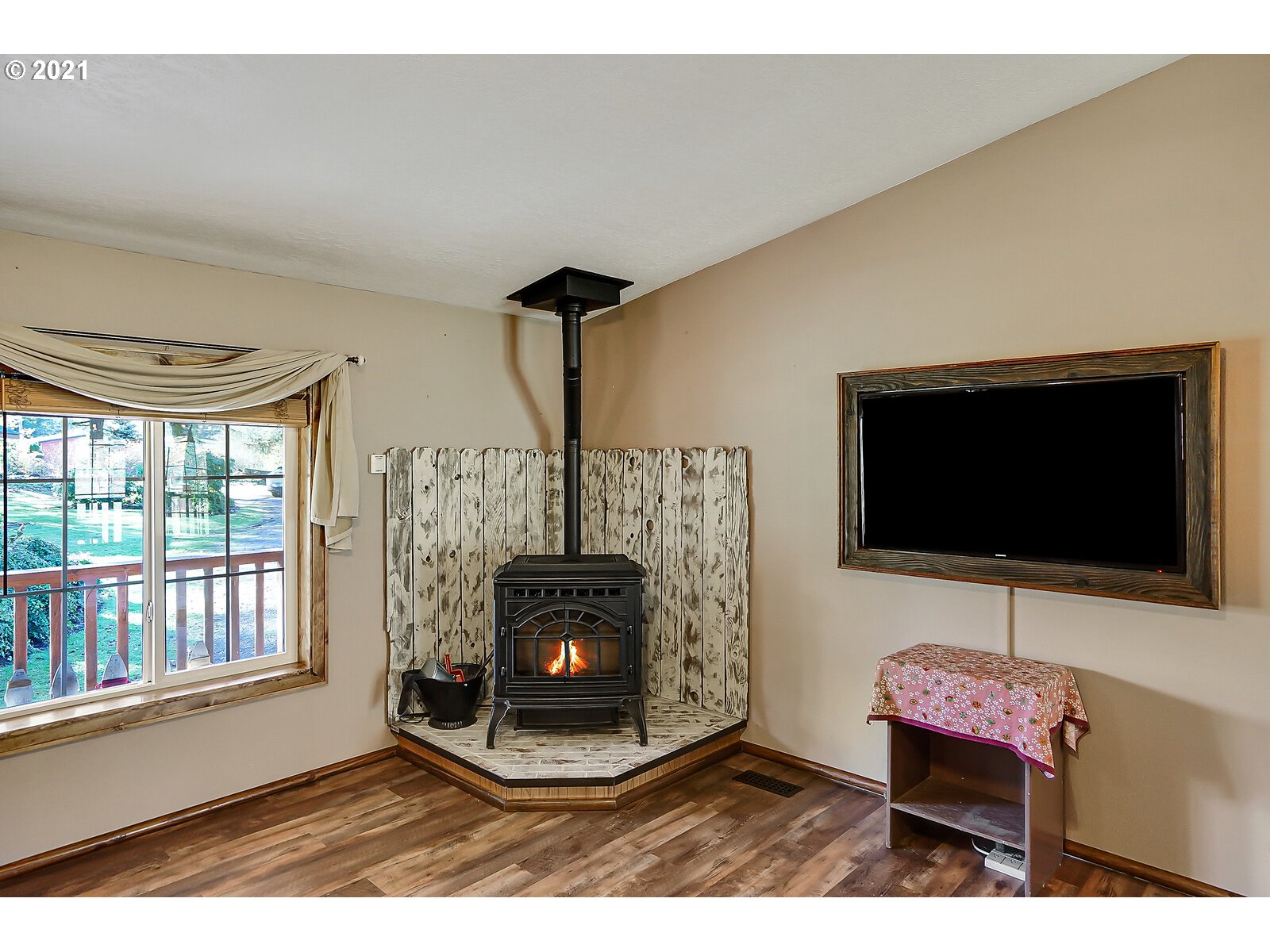 1725 Main Street Lyons, OR 97358 - Photo 6 of 32 a living room with furniture a flat screen tv and a fireplace