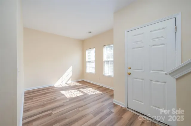 a view of a room with wooden floor and windows