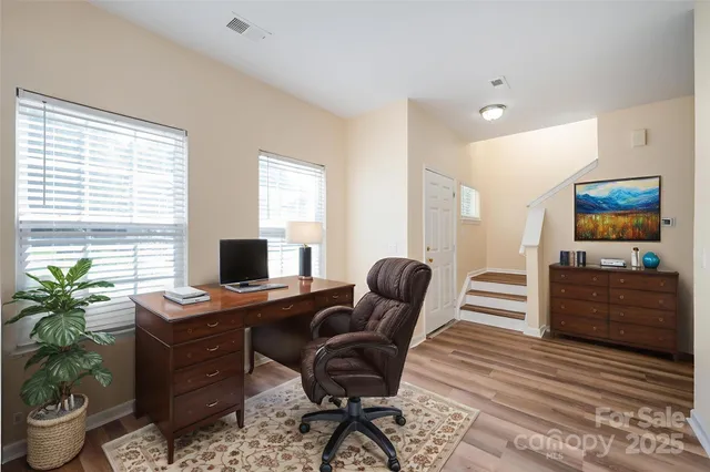 a view of a workspace with furniture and a window