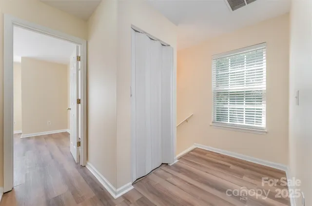 a view of a livingroom with wooden floor and a window