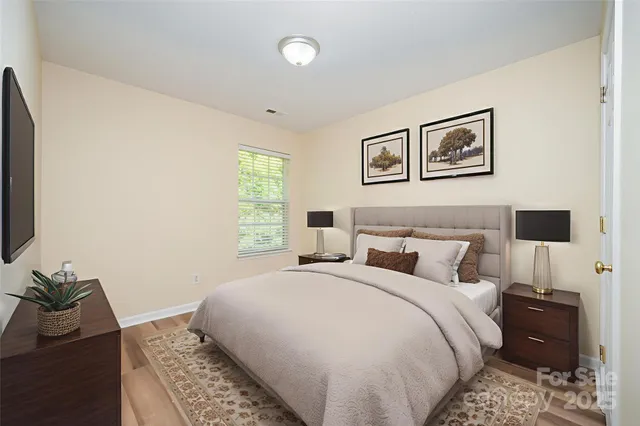 a bedroom with a bed and wooden floor