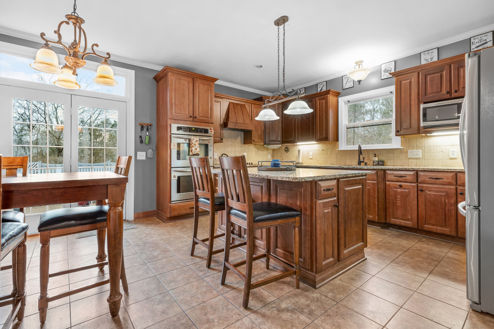 3354 Old Franklin Road Antioch, TN 37013 - Photo 24 of 46 a kitchen with stainless steel appliances kitchen island granite countertop a table chairs and a refrigerator