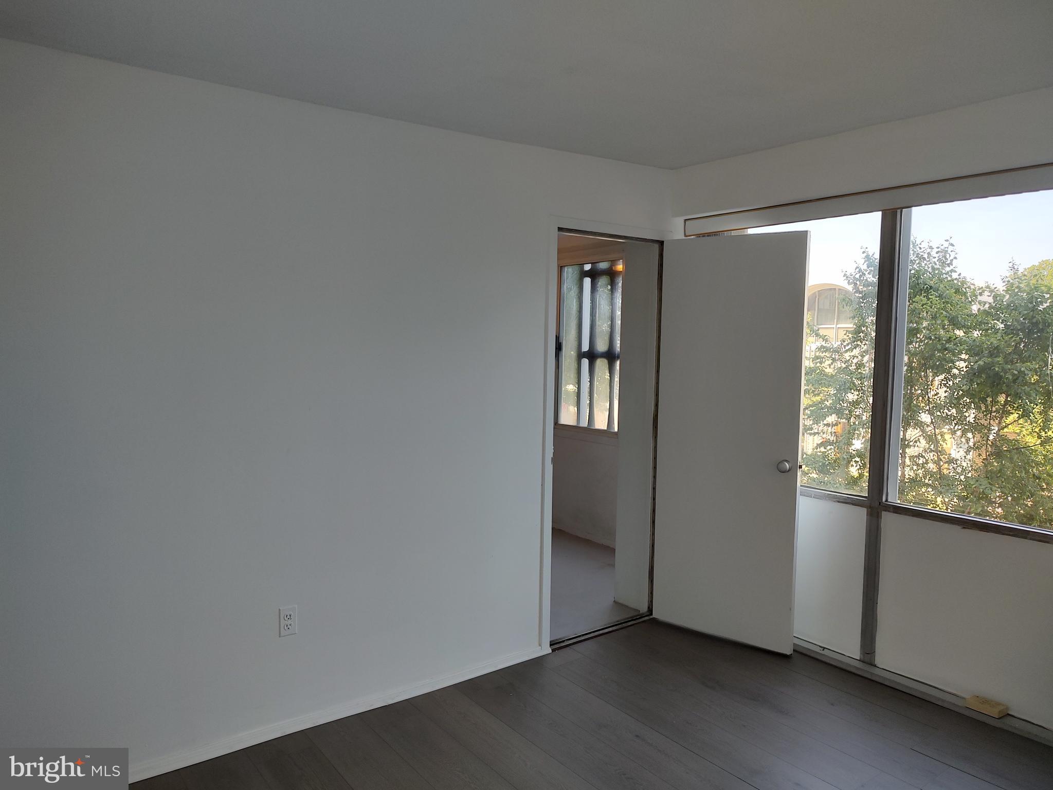 1301 Delaware Avenue Southwest, Unit N103 Washington, DC 20024 - Photo 12 of 26 an empty room with wooden floor and windows