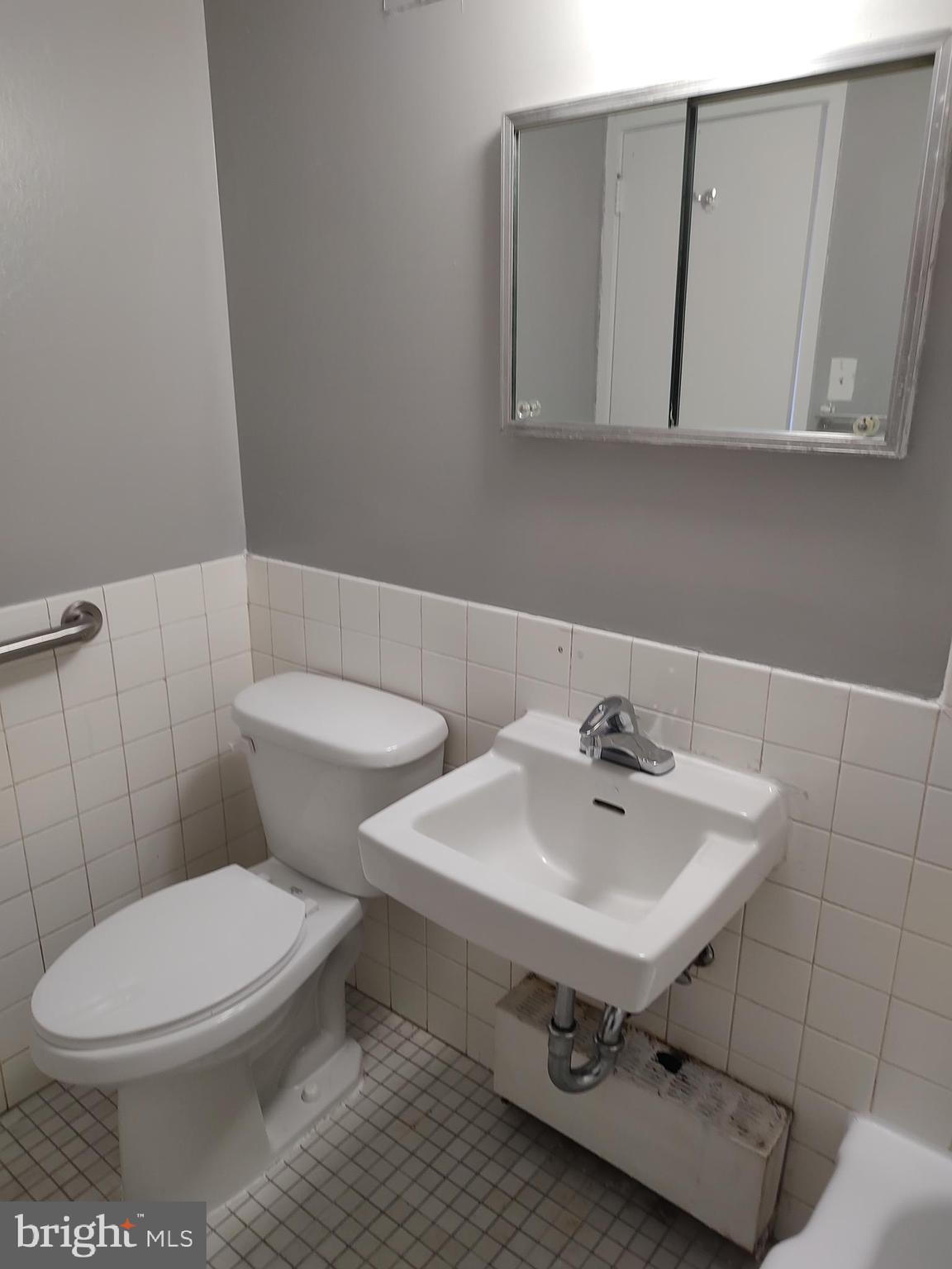 1301 Delaware Avenue Southwest, Unit N103 Washington, DC 20024 - Photo 18 of 26 a bathroom with a sink a toilet and mirror