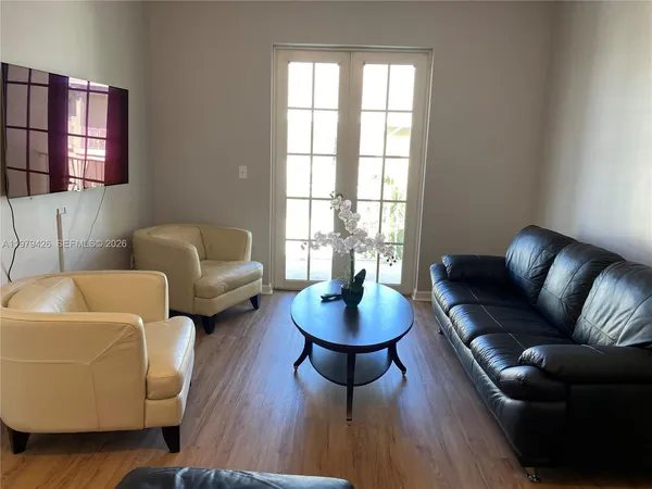 a living room with furniture and wooden floor
