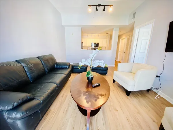 a view of a hallway with wooden floor and furniture