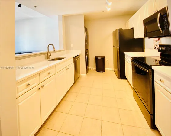 a kitchen with stainless steel appliances white cabinets and a refrigerator
