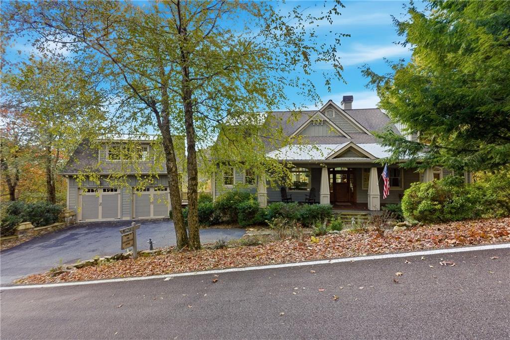 a front view of a house with a yard and tree s