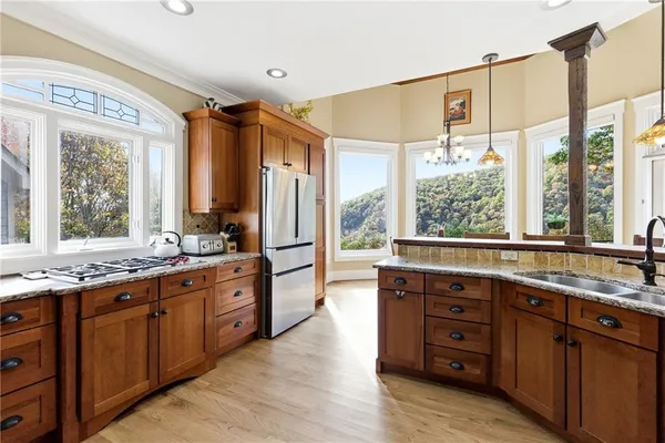 a kitchen with stainless steel appliances granite countertop a refrigerator and a stove top oven
