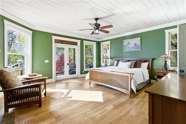 a bedroom with a bed and a chandelier next to a window
