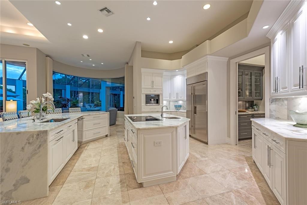 2701 Buckthorn Way Naples, FL 34105 - Photo 11 of 48 a large kitchen with stainless steel appliances lots of white cabinets