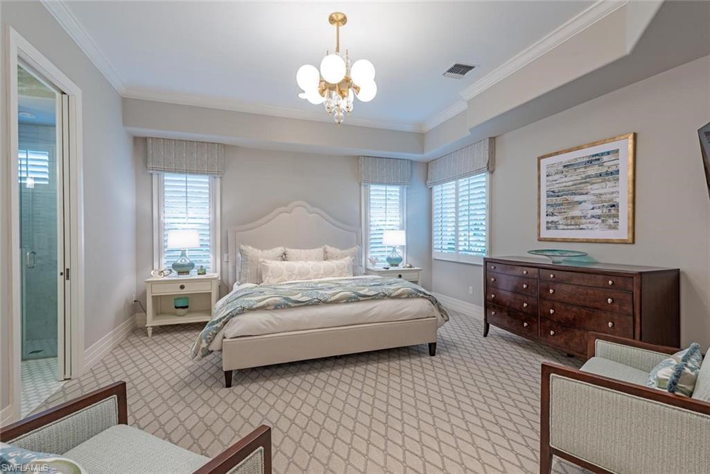2701 Buckthorn Way Naples, FL 34105 - Photo 17 of 48 a spacious bedroom with a bed and wooden floor