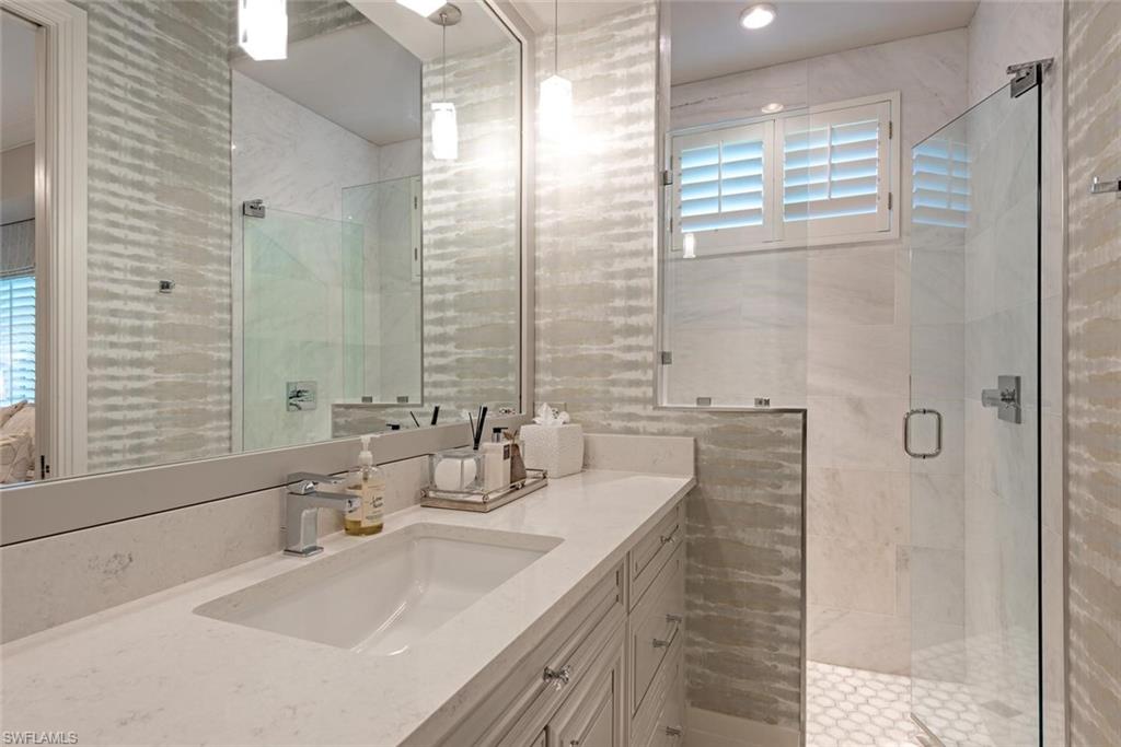 2701 Buckthorn Way Naples, FL 34105 - Photo 18 of 48 a bathroom with double vanity and a bathtub