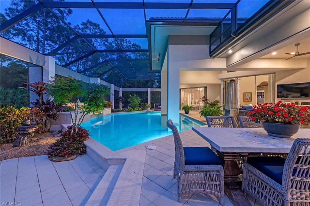 2701 Buckthorn Way Naples, FL 34105 - Photo 28 of 48 a view of a patio with table and chairs potted plants with wooden floor