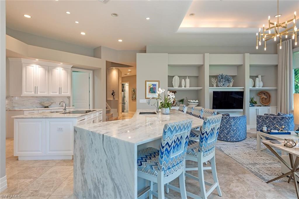 2701 Buckthorn Way Naples, FL 34105 - Photo 8 of 48 a large kitchen with granite countertop a stove a sink a dining table and chairs