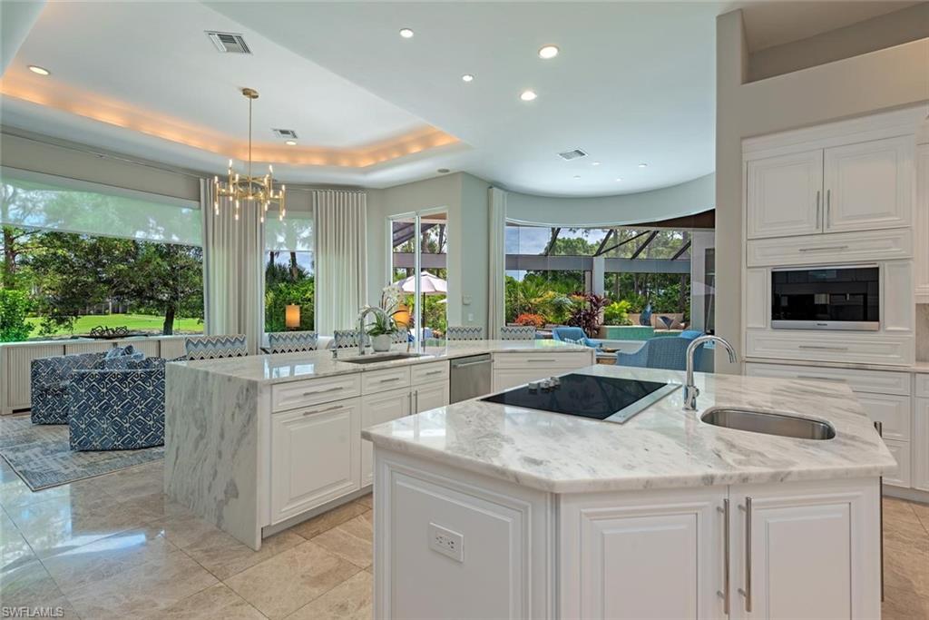 2701 Buckthorn Way Naples, FL 34105 - Photo 9 of 48 a kitchen with granite countertop a sink and white cabinets