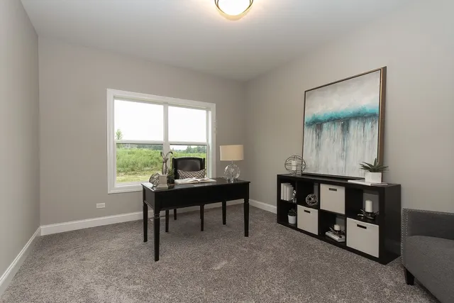 a view of a workspace with furniture and a window