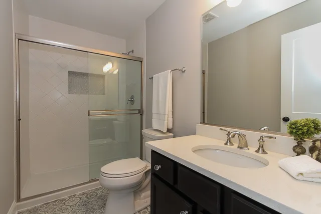 a bathroom with a sink a toilet and shower