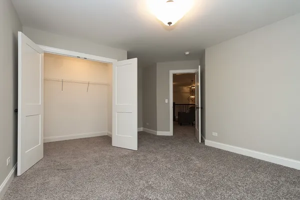 an empty room with closet and a bathroom