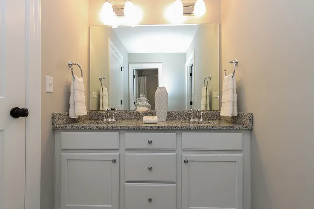 a bathroom with a granite countertop sink and a mirror