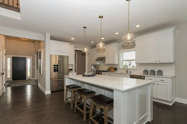 a kitchen with a sink a center island a counter space and stainless steel appliances