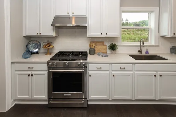 a kitchen with white cabinets and appliances