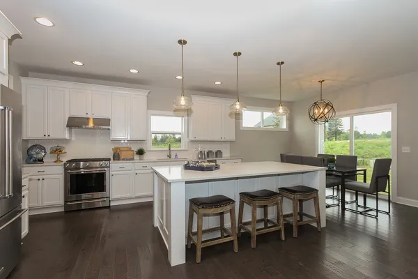 a kitchen with a stove a table and chairs in it
