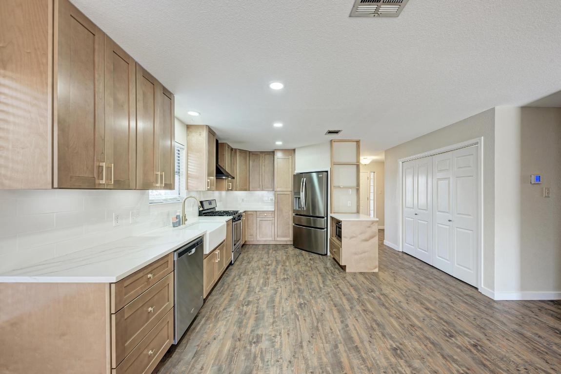 2317 Friarcreek Loop Round Rock, TX 78664 - Photo 9 of 36 a kitchen with stainless steel appliances sink refrigerator and wooden floor