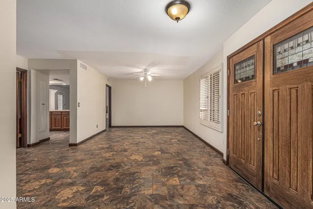 a view of an empty room with a window and wooden floor