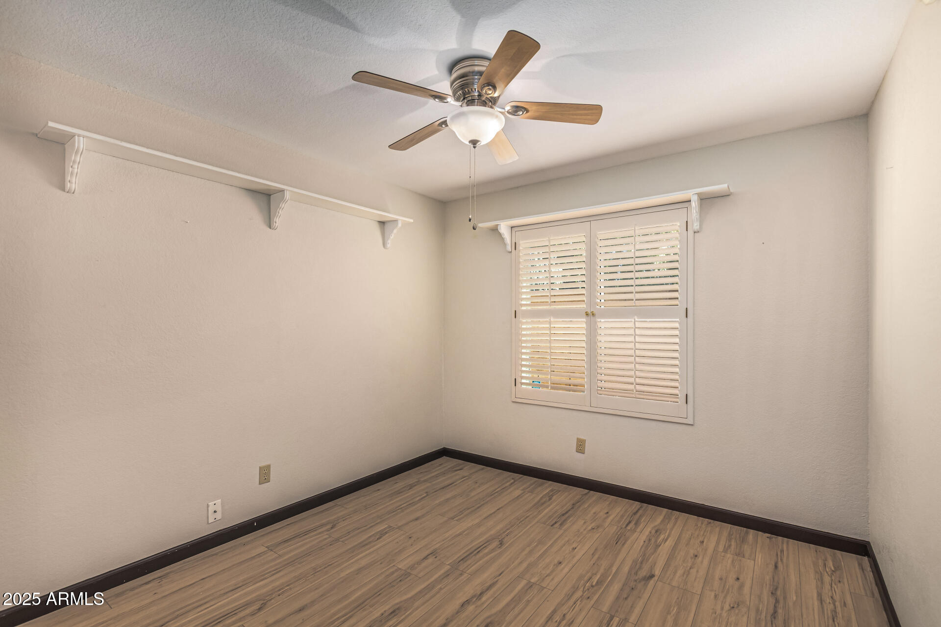 5109 East Kathleen Road Scottsdale, AZ 85254 - Photo 40 of 54 a view of an empty room with a window and wooden floor