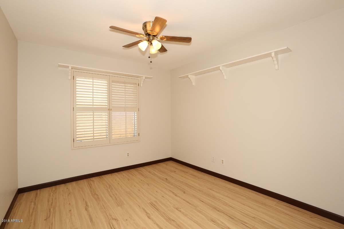 5109 East Kathleen Road Scottsdale, AZ 85254 - Photo 6 of 54 an empty room with wooden floor fan and windows