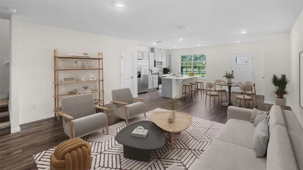 a living room with furniture kitchen view and a large window