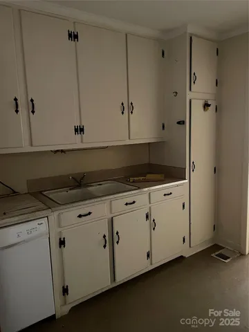 a kitchen with granite countertop white cabinets and white appliances