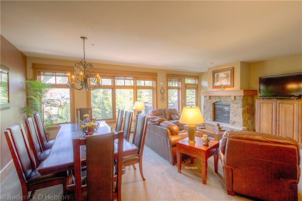 280 Trailhead Drive, Unit 3043 Keystone, CO 80435 - Photo 6 of 24 a view of a dining room with furniture a fireplace and large windows
