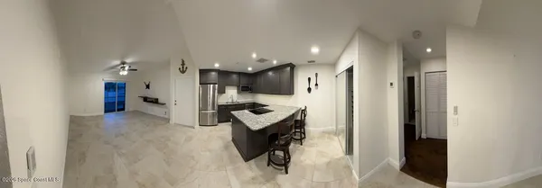 a view of a kitchen with refrigerator and wooden floor