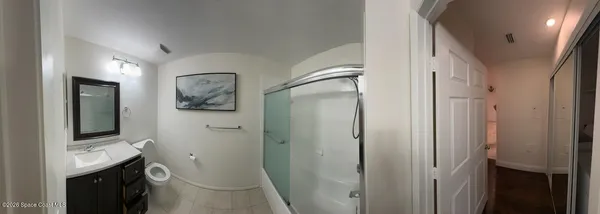 a bathroom with a sink and mirror with toilet