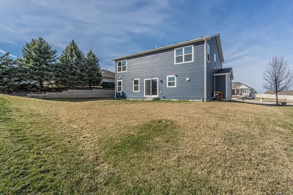 a front view of house with yard and trees in the background
