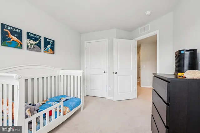 a bedroom with furniture a baby crib and a large window