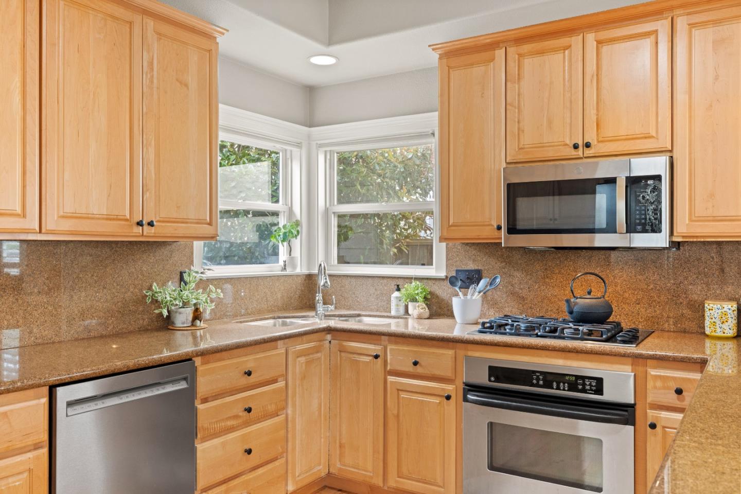 2549 Colonial Circle Watsonville, CA 95076 - Photo 18 of 54 a kitchen with stainless steel appliances granite countertop white cabinets a stove a sink and dishwasher with wooden floor
